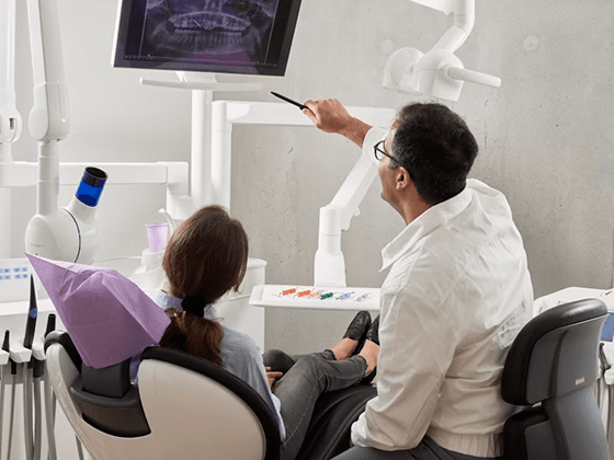Dentista mostrando a escala de cor dos dentes para paciente em Goiânia