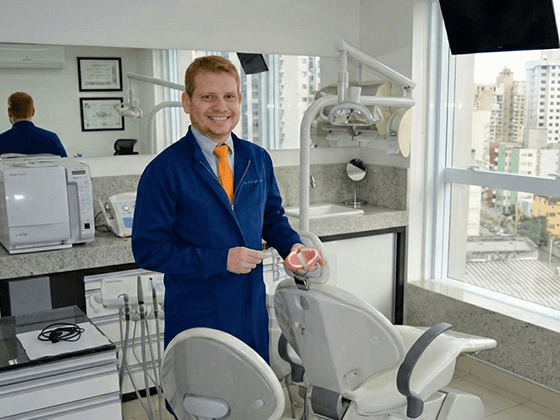 Dentista mostrando a escala de cor dos dentes para paciente em Goiânia